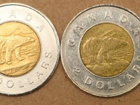 The fake toonie, left, with the "two-toed" feature on the polar bear, beside a real toonie with a more uniform paw, right.