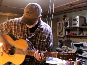 Simon Budd plays the first guitar he ever made in his workshop in Fort McMurray on Wednesday, August 3, 2022. Laura Beamish Fort McMurray Today/Postmedia Network