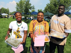 Hannah Eong, Lucia Aire and Commissioner Andrew Cameron take food at the Afro-Canadian Arts and Culture Festival organized by the Rehoboth Alliance at J. Howard Pew Park on Saturday, August 13, 2022.  Vincent McDermott/Fort McMurray Today/ Postmedia Network
