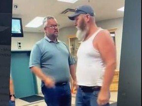 An unidentified man in a white tank top was captured on video shouting obscenities at Deputy Prime Minister Chrystia Freeland as she entered an elevator at City Hall in Grande Prairie, Alta., before he was escorted out of the building.