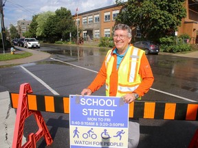 Roger Healey, a volunteer with Kingston Coalition for Active Transportation, in front of Central Public School on Sydenham Street in Kingston on Wednesday.