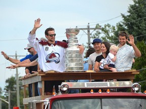 Colorado Avalanche player Kurtis MacDermid and the Stanley Cup ride down Lakeshore Boulevard in Sauble Beach on the back of a fire truck on Monday.