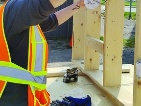 A participant in the Build This City program gets practical experience in house wiring;