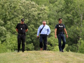 Detectives from the Sarnia police's criminal investigations unit look for clues Wednesday in the southern edge of the Aamjiwnaang First Nation as the search for Trevor Chaput, a 33-year-old Sarnia man reported missing July 6, continues. (Terry Bridge/Sarnia Observer)