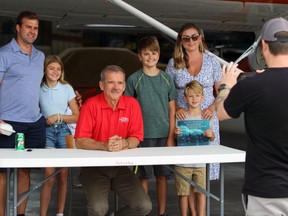 From left, Derek Martin, daughter Lydia, 12, son Conor, 14, wife Jenny and son Colin, 6, pose for a photo with retired astronaut Chris Hadfield, middle, during a fly-in event at the Sarnia Chris Hadfield Airport on Saturday. Terry Bridge/Sarnia Observer/Postmedia Network