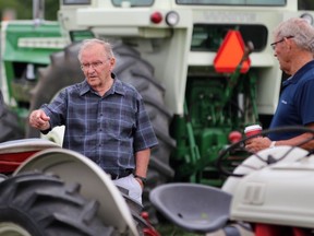 Quebec resident Dale MacLeod, left, and brother Jim MacLeod from Sarnia check out a row of tractors at the Western Ontario Steam Thresher's Association's event at the Forest Fairgrounds on Sunday.  Terry Bridge/Sarnia Observer/Postmedia Network