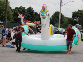 Participants carry a large inflatable to the water in Sarnia Sunday to take part in the St. Clair River Float Down.