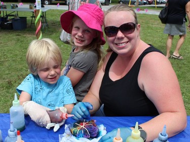 Brittany Wikinson of Simcoe helps her children, John, 5, and seven-year-old Olivia, tie dye some T-shirts in the KidZone on Sunday, July 31 at the Simcoe Heritage Friendship Festival. MICHELLE RUBY