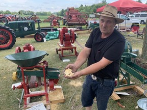 Jake Tapp of Lowbanks holds some corn produced by an antique Massey Harris grain grinder on Monday, Aug. 1. The grinder was built in Brantford in the early 1900s and was one of several machines Tapp had on display at the Walpole Antique Farm Machinery Association's Heritage Day Weekend. VINCENT BALL