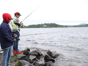 Mallory Bennett, left, and Koady Shogga braved the inclement weather in Sudbury, Ont. on Wednesday August 3, 2022 to try their luck at fishing. John Lappa/Sudbury Star/Postmedia Network