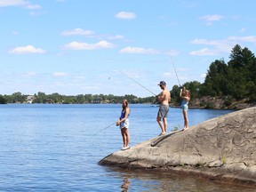 Olivia Roleff, left, her sister, Rylea, and Joe Arcan try their luck at fishing at Ramsey Lake in Sudbury, Ont. on Friday August 12, 2022. John Lappa/Sudbury Star/Postmedia Network