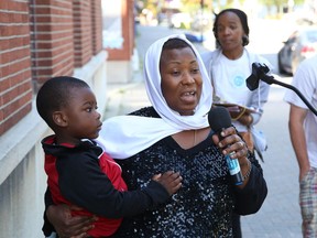 Temi Osuntokun holds her son, Daniel, 3, while making a point at a rally outside of Sudbury MP Viviane Lapointe's constituency office in Sudbury on Aug. 15. The event was held in support of full immigration status and equal rights for all migrants.