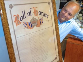 Mike Baker, Elgin County Museum curator, looks over First World War honour roll from the now-closed Rodney branch of the Royal Canadian Legion. (Eric Bunnell/Special to Postmedia Network)