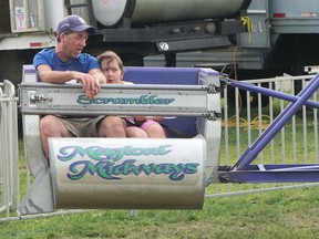 Mikaela Ledoux and her grandfather, Dave Matthews, ride the Scrambler during a Sunday visit to the midway at the Tillsonburg Fair.  CHRIS ABBOTT