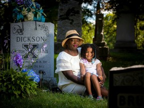 Donna Dickson, mother of the late Ashton Dickson, with her granddaughter, four-year-old Alianna Dickson, at Beechwood Cemetery.