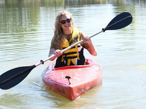 Kelsey Nydam, executive director of the Downtown Wallaceburg BIA, takes one of the kayaks from the new Whimsies Paddle Adventure rental service onto the Sydenham River Sept. 1, 2022. (Tom Morrison/Postmedia Network)