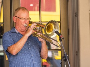 Dan Douglas, from the Dan Douglas duo, plays a trombone for pedestrians walking along Belleville's Front Street on Saturday during the city's first Jazz festival. ALEX FILIPE