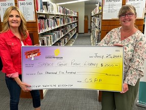 Spruce Grove Public Library Director Leanne Myggland-Carter (right) accepts a $2,500 donation from Coordinated Suicide Prevention Program representative Michelle Zoschke (left) on Monday, July 25, 2022. File photo.
