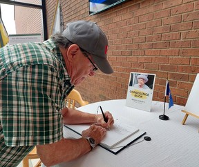 David Hebblethwaite signs a book of condolence for Queen Elizabeth II at the Civic Center in Chatham on Monday.  The book will be available to sign from 8:30 am to 4:30 pm until Friday.  Ellwood Shreve/Postmedia
