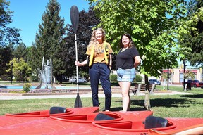 Kelsey Nydam, executive director of the Downtown Wallaceburg BIA, and Emma McIntyre, Canada Summer Jobs employee, are shown with the kayaks used for the BIA's news rental service at Civic Square Park Sept. 1, 2022. (Tom Morrison/Chatham This Week)