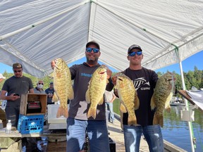 Andy Carlson and Troy Norman hold up part of their winning catch at Bassin' For Bucks in Sioux Narrows over the weekend.