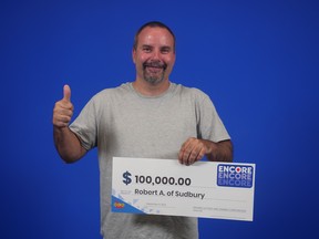Robert Aubin of Sudbury celebrates his $100,000 Encore win while collecting his prize in Toronto.