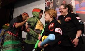 Shishir Inocalla, the stunt actor for Michaelangelo in Teenage Mutant Ninja Turtles 3, signs Troy Pellerin's Ninja Turtles costume as his sister, Angel, centre-right, and Claudine Bordeau with Wallaceburg Martial Arts look on at the Wallaceburg & District Museum Sept. 14. (Tom Morrison/Postmedia Network)