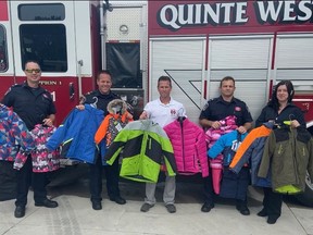 Members of the the Quinte West Professional Firefighters Association Local 1328 hold up children's coats as they announce the start of the 31st annual Coats for Kids program. Submitted