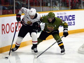 Paul Christopoulos of the North Bay Battalion tries to check Gavin Bryant of the Owen Sound Attack in an exhibition game in Owen Sound on Tuesday night.