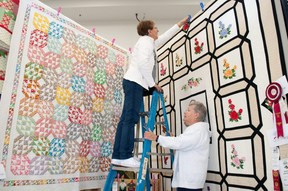Susan Elliott holds the ladder for Jill Thorpe while they set up a quilt display at the Stratford Rotary Complex on Thursday, the first day of the 181st Stratford Fall Fair. The fair, making a full-scale return for the first time since 2019, runs until Sunday. (Chris Montanini/Stratford Beacon Herald)