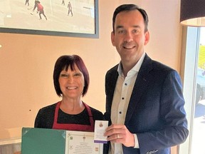 Banff-Airdrie MP Blake Richards presents Airdrie volunteer Wendy Contant with the Queen's Platinum Jubilee Award on September 21, giving her a brief break from decorating Smile Cookies at Tim Hortons. Photo courtesy of Blake Richards.