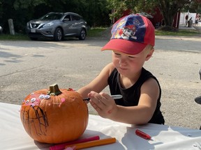 Three-year-old Cooper Oudshoorn of Auburn decorates a pumpkin during the Lucknow Fall Fair on Sept. 17. Photo by Kelly Kenny/Lucknow Sentinel.