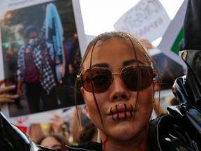 A demonstrator has her lips painted like sewn as she takes part in a protest following the death of Mahsa Amini in Iran, near the Iranian consulate in Istanbul, Turkey September 29, 2022. REUTERS/Dilara Senkaya/File Photo