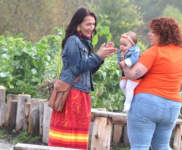 Tracie Louttit speaks with Angela Caputo and her child Leo Gayle Caputo, eight months, and Terri Tice, not shown, at the sacred medicine garden at grand opening of Shingwauk Kinoomaage Gamig on Friday, Sept. 30, 2022 in Sault Ste. Marie, Ont. (BRIAN KELLY/THE SAULT STAR/POSTMEDIA NETWORK)