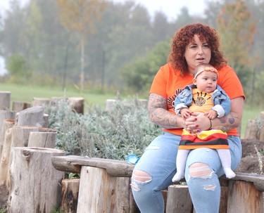 Angela Caputo and her child Leo Gayle Caputo, eight months, at the sacred medicine garden at grand opening of Shingwauk Kinoomaage Gamig on Friday, Sept. 30, 2022 in Sault Ste. Marie, Ont. (BRIAN KELLY/THE SAULT STAR/POSTMEDIA NETWORK)