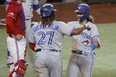 Toronto Blue Jays' Vladimir Guerrero Jr. (27) congratulates Bo Bichette, right, after Bichette's two-run home run against the Texas Rangers.