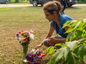 Ruby Works places flowers at the home of a victim who has been identified by residents as Wes Petterson in Weldon, Sask., on Monday, Sept. 5, 2022. Works said that the 77-years-old victim was like an uncle to her. Saskatchewan RCMP say arrest warrants have been issued for two suspects in the deadly stabbing rampage. THE CANADIAN PRESS/Heywood Yu