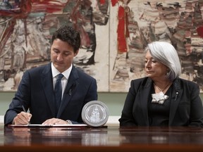 Governor General Mary Simon looks on as Prime Minister Justin Trudeau signs documents during an accession ceremony at Rideau Hall, in Ottawa, Saturday, Sept. 10, 2022. THE CANADIAN PRESS/Adrian Wyld