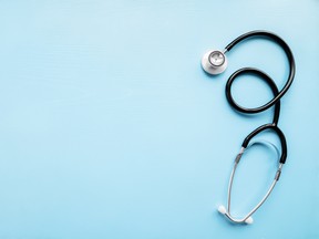Stethoscope on pastel blue table. Doctor tool. Healthcare concept. Empty place for text. Flat lay. Closeup. Top down view.