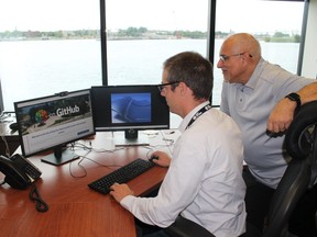 Dan Gowans, system analyst/programmer and IT Manager Frank Coccimiglio check out the City of Sault Ste. Marie's  repositories on GitHub. Gowarns created the website that shows rankings of each municipality's programs.  PHOTO SUBMITTED.