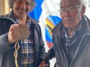 Chief Allan Adam holds up the Treaty 8 Medallion given to the Athabasca Chipewyan First Nation in 1899 after it was repatriated from the Royal Alberta Museum on Sept. 6, 2022. With him is Elder Rene Bruno, whose grandfather witnessed the treaty being signed. Photo supplied by Jay Telegdi/ACFN