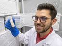 John Chmiel, a microbiology and immunology doctoral student at Western University, holds up a sample of fecal matter kept frozen at -80 C at St. Joseph's hospital in London, on Wednesday, Sept. 14, 2022. St. Joseph’s Health Care is needing healthy adults willing to donate fecal matter for the beneficial gut microbes harvested to treat stubborn, potentially fatal bowel infection. (Mike Hensen/The London Free Press)