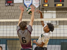 Jacob Marckesano (left) of the Pauline Johnson Thunderbirds tries to block a spike by Pacheco Deleon of the St. John’s Eagles during a senior boys high school volleyball match on Tuesday in Brantford.