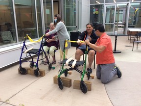 Willow Square Continuing Care Centre residents Grace Wanderingspirit and Patricia Gabriel participate in a slingshot target practice game, with the assistance of AHS social work student Susan Greening and occupational therapist Kent Tsui. Photo supplied by AHS