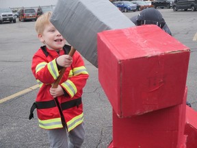Ryker Malvern, 3, uses Thor's hammer to help smash his way through the Kids Can Fly Superhero Day obstacle course in Brantford on Monday. CHRIS ABBOTT