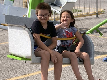 Kade Maracle-Hess (left) and Ayvah Maracle-Hess take a spin on a midway ride on Saturday at the Six Nations Fall Fair. Susan Gamble