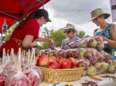 Eva Thorpe (left) helps Jessie Osborne and Laurie DiMeo with their purchase at the Brantwood Farms booth on Sunday September 18, 2022 during Apple Fest in St. George, Ontario. Brian Thompson/Brantford Expositor/Postmedia Network