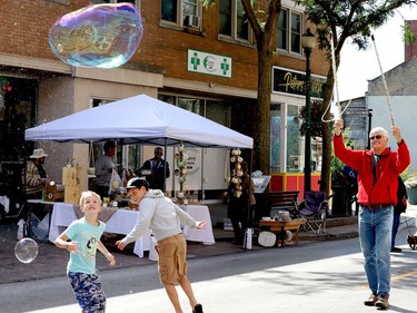 Isaac Toohey-Glockler, left, and François Langlois chase bubbles produced by Victor Limbeek on King Street West Saturday morning during Culture Days. (RONALD ZAJAC/The Recorder and Times)