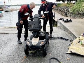 Stephen Hatch, left, and Stéphan Senécal of the local S.O.S. dive group, look over a motorized scooter belonging to an elderly man who fell into the water on Saturday, after retrieving the vehicle on Monday afternoon. (RONALD ZAJAC/The Recorder and Times)