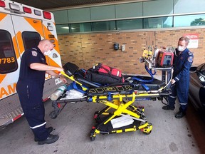 Matt Laverty, back, an advanced care flight paramedic, and Andrew Whittemore, a critical care paramedic, are seen here preparing to pick up a patient in Windsor to be transferring to hospital in London to receive a higher level of treatment for a heart condition.  They are part of the team that works out of the now permanent critical care land ambulance base in Chatham-Kent.  PHOTO Ellwood Shreve/Chatham Daily News